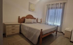 a bedroom with a bed and a dresser and a window at Terra e Mar in Amorosa