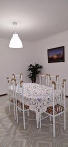 a white dining room table with chairs and a white ceiling at Terra e Mar in Amorosa