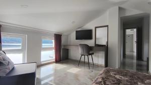 a bedroom with a bed and a desk with a television at Къща за гости Орфей in Dospat