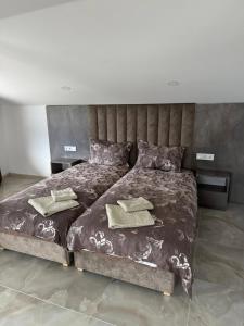 a bedroom with a large bed with two towels on it at Къща за гости Орфей in Dospat