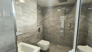 a bathroom with a shower and a toilet and a sink at Къща за гости Орфей in Dospat +42 photos