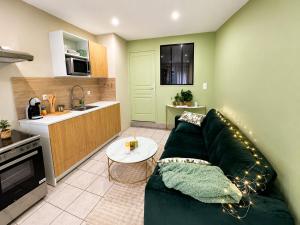 a living room with a green couch and a kitchen at Appartement hyper centre de Mons in Mons