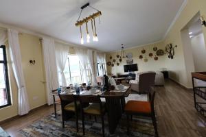 a dining room and living room with a table and chairs at Shamba la Chini in Nairobi