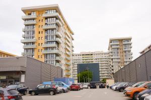 a parking lot with cars parked in front of tall buildings at Konstanzer 95 - Cozy Studio - Iulius Mall - AC in Iaşi