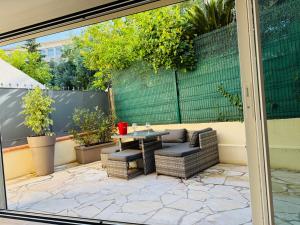 a patio with a table and chairs and plants at CANNES Maison Design "DOLCE VITA" in Cannes