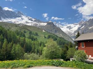 a house with a view of a snow covered mountain at Chalet de montagne sur le TMB in La Fouly