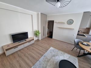 a living room with a flat screen tv and a table at Hubane korter Paalalinnas in Viljandi