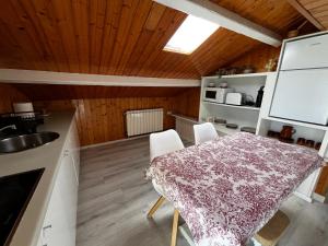 a kitchen and dining room with a table and chairs at Atico de madera Apartamento en Rinlo, RIBADEO in Ribadeo