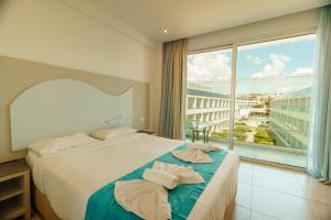a bedroom with a bed and a large window at Nicholas Color Hotel in Ayia Napa