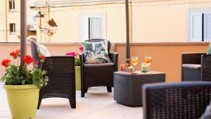 a patio with chairs and tables with glasses of wine at Harmonia Rooms by Italy Home Experience in Civitavecchia