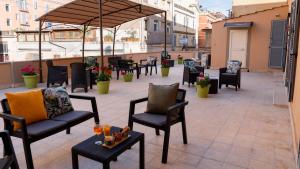 a patio with chairs and tables on a balcony at Harmonia Rooms by Italy Home Experience in Civitavecchia