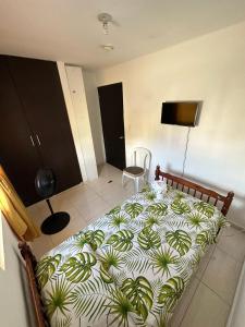 a bedroom with a large bed with a plant pattern at Cuartos amoblados arraijan in Palo Diferente