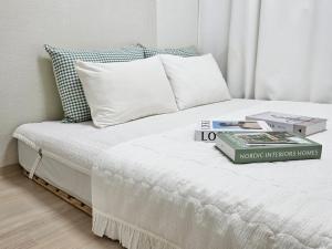a white bed with two books on top of it at 행궁동-House1 in Suwon