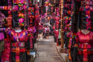 a group of people walking down a street in a store at Hotel casa de doña Rome in Chichicastenango