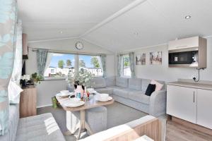 a living room with a couch and a table at Lovely 3 bedroom holiday home in Seton Sand caravan park Wi-Fi Xbox in Edinburgh