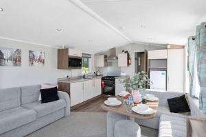 a living room with a couch and a table at Lovely 3 bedroom holiday home in Seton Sand caravan park Wi-Fi Xbox in Edinburgh