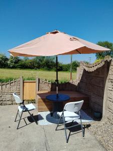 a table and two chairs with an umbrella at Willow House in Newtownshandrum