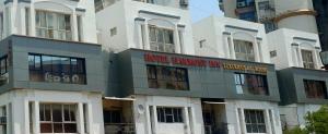 a large white building with a sign on it at Hotel Harmony Inn in Ahmedabad +22 photos