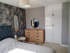 a bedroom with a bed and a dresser and mirror at Willow House in Newtownshandrum