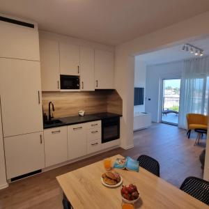 a kitchen with a table with a plate of food on it at Apartman Zalar in Lopar