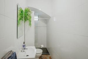 a white bathroom with a toilet and a sink at Pisito del Pueblo in Navaluenga +18 photos