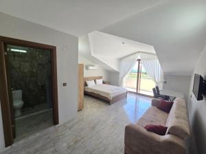 a bedroom with a bed and a couch in a room at Olive Tree Apart Hotel in Muğla