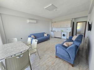 a living room with blue couches and a kitchen at Olive Tree Apart Hotel in Muğla +32 photos