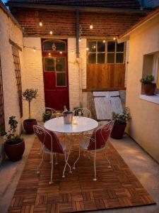 a patio with a table and chairs and a red door at Gîte cosy Vertus avec terrasse privé proche maisons de Champagne Epernay Reims in Vertus
