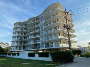 a large white building with a round top at Modern Condo Infinity Pool Gym Near Beach in Bang Sare