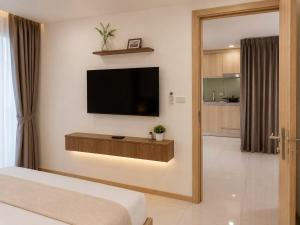 a bedroom with a flat screen tv on a wall at Modern Condo Infinity Pool Gym Near Beach in Bang Sare