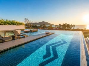 a large swimming pool with a blue poolvisorvisorvisor at Modern Condo Infinity Pool Gym Near Beach in Bang Sare