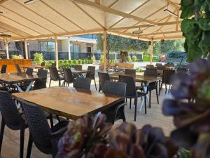 a row of tables and chairs under an umbrella at Olive Tree Apart Hotel in Muğla