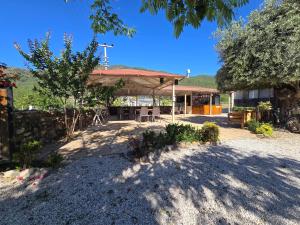 a building with a table and chairs in a yard at Olive Tree Apart Hotel in Muğla