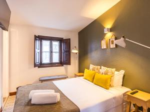 a bedroom with a large white bed with yellow pillows at Foral Guest House in Óbidos