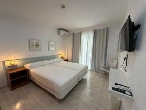 a bedroom with a bed and a flat screen tv at Fleming Center in Benidorm