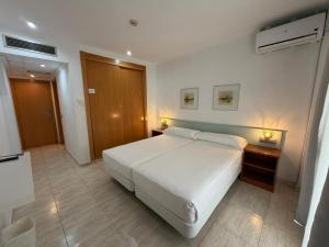 a bedroom with a white bed and two night stands at Fleming Center in Benidorm +12 photos