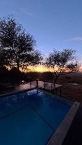 a swimming pool with a sunset in the background at Tulani Boutique Lodge - Includes Game drives and Meals in Grietjie Game Reserve +43 photos