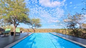 a swimming pool with two chairs on a wooden deck at Tulani Boutique Lodge - Includes Game drives and Meals in Grietjie Game Reserve