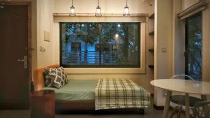 a room with a window with a couch and a table at Cozy & Spacious 2BR Private House in Siem Reap
