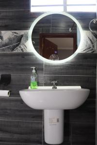 a bathroom with a white sink and a mirror at Larami House Narok in Narok +87 photos