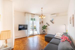 a living room with a couch and a tv at Casa Iris h Sanremo in Sanremo