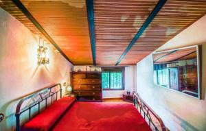 a bedroom with a red bed and a wooden ceiling at Casa La Seguiriya in Las Lagunillas