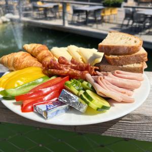 a plate of food with meats and cheese and bread at Apartments by Mara Holiday in Liptovský Mikuláš +76 photos