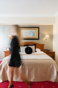 a woman is walking around a bed in a hotel room at Hotel Niko in Zadar