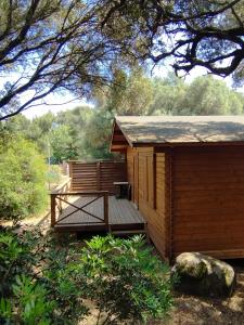 a small wooden cabin with a wooden deck at chalets bois 150m de la plage in Olmeto