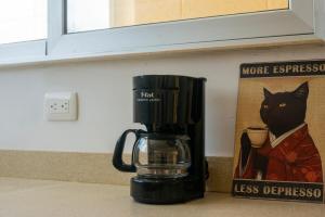 a black coffee maker sitting next to a picture of a black cat at Tulum Paradise - Private Pool & Rooftop Deck in Tulum