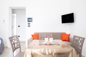 a dining room with a table and a couch at Almària - Rooms e Garden in Nardò