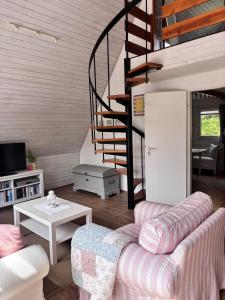 a living room with a couch and a spiral staircase at Ferienhaus Wittensee in Bünsdorf