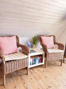 two wicker chairs and a book shelf with books at Ferienhaus Wittensee in Bünsdorf