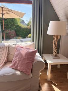 a living room with a couch and a table with a lamp at Ferienhaus Wittensee in Bünsdorf